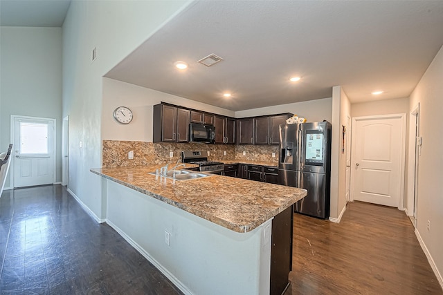 5407 Matilda Bend Ln, Katy, TX 77449 - kitchen with dark brown cabinetry, backsplash, dark wood-style floors, and appliances with stainless steel finishes