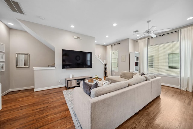 living area featuring visible vents, dark wood-style flooring, and baseboards