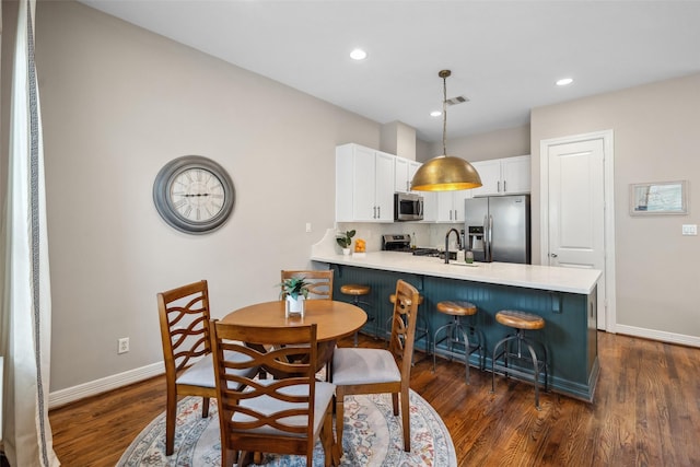 dining room with dark wood-style flooring, baseboards, visible vents, and recessed lighting