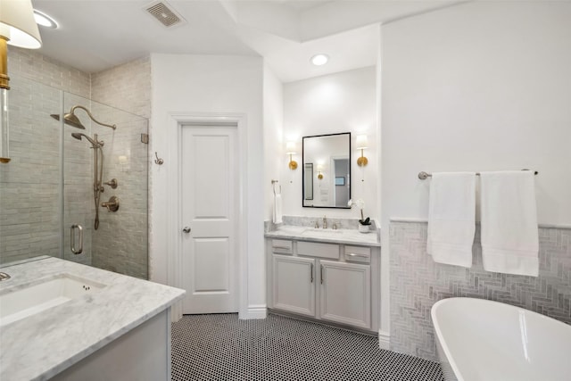 bathroom featuring vanity, visible vents, a stall shower, tile patterned flooring, and a soaking tub