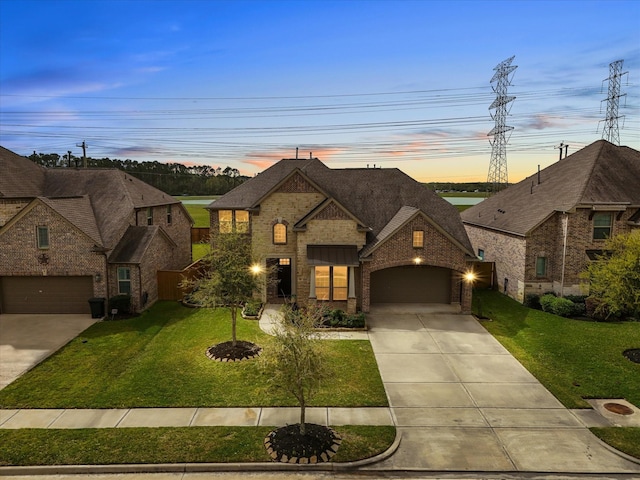 2712 Ahnya Ln, League City, TX 77573 - french provincial home featuring an attached garage, brick siding, driveway, a shingled roof, and a yard
