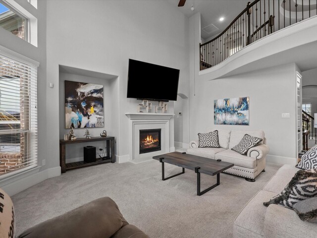 2712 Ahnya Ln, League City, TX 77573 - carpeted living room featuring plenty of natural light, baseboards, ceiling fan, and a glass covered fireplace