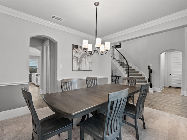 2712 Ahnya Ln, League City, TX 77573 - dining space featuring stairway, ornamental molding, a chandelier, arched walkways, and visible vents