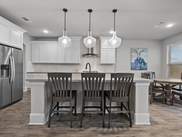 2712 Ahnya Ln, League City, TX 77573 - kitchen featuring stainless steel fridge with ice dispenser, an island with sink, visible vents, and a sink