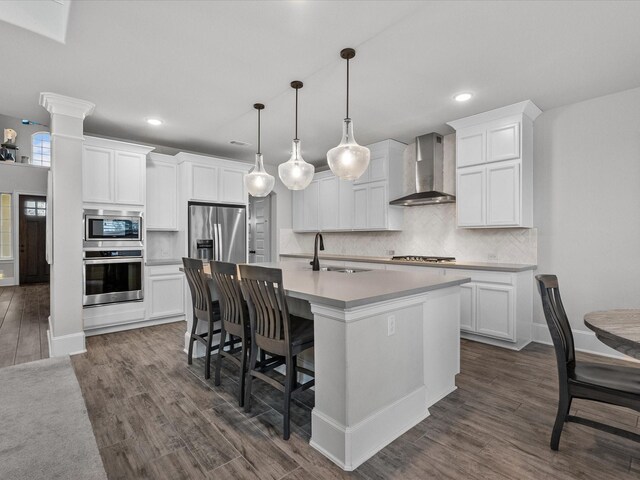 2712 Ahnya Ln, League City, TX 77573 - kitchen with dark wood-style flooring, stainless steel appliances, an island with sink, wall chimney range hood, and backsplash
