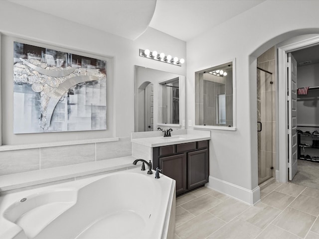 2712 Ahnya Ln, League City, TX 77573 - bathroom with vanity, a walk in closet, baseboards, a shower stall, and a garden tub