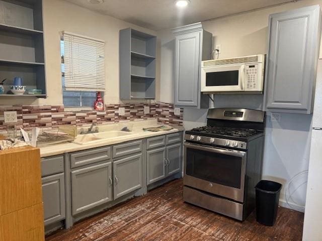 7511 Bonham St, Houston, TX 77020 - kitchen with stainless steel range with gas cooktop, white microwave, gray cabinetry, open shelves, and a sink