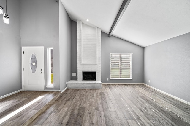 unfurnished living room with high vaulted ceiling, beamed ceiling, a brick fireplace, baseboards, and hardwood / wood-style floors