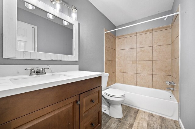full bath with toilet, shower / tub combination, wood finished floors, and vanity