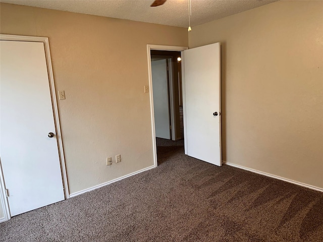unfurnished bedroom featuring dark colored carpet and a textured ceiling
