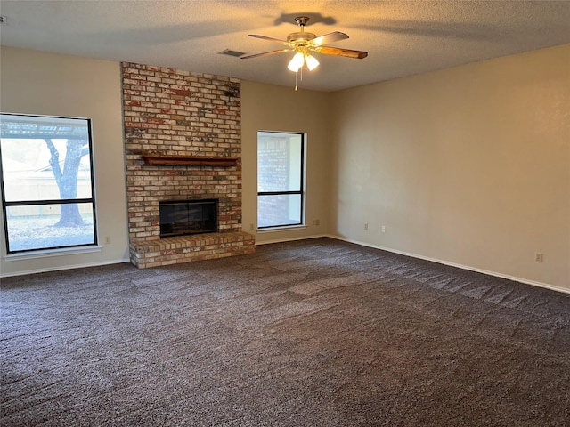unfurnished living room with a wealth of natural light, visible vents, a textured ceiling, and ceiling fan