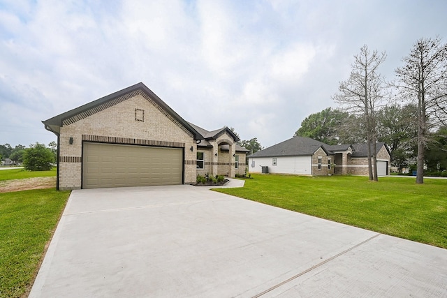 635 Lily St, Prairie View, TX 77484 - french provincial home with concrete driveway, a front yard, a garage, brick siding, and stone siding