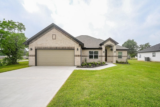635 Lily St, Prairie View, TX 77484 - french country inspired facade featuring brick siding, an attached garage, a front yard, driveway, and a shingled roof