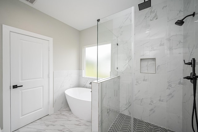 635 Lily St, Prairie View, TX 77484 - full bathroom featuring marble finish flooring, a marble finish shower, a freestanding tub, tile walls, and a wainscoted wall