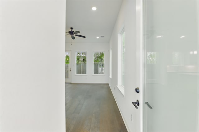 corridor featuring dark wood-type flooring, baseboards, and recessed lighting