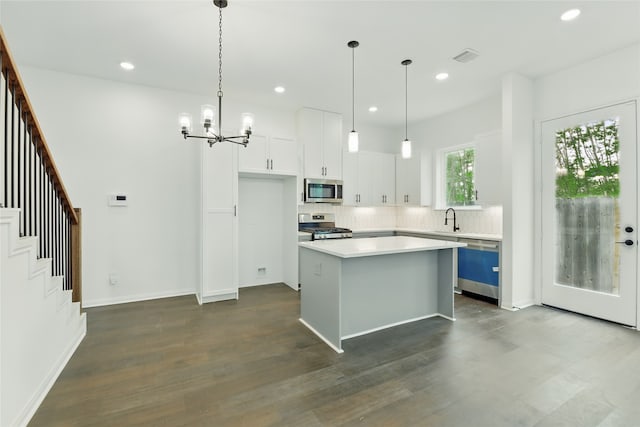 kitchen featuring light countertops, stainless steel appliances, recessed lighting, a sink, and a notable chandelier