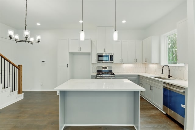 kitchen with dark wood-style flooring, a sink, tasteful backsplash, and appliances with stainless steel finishes