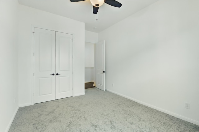 unfurnished bedroom featuring baseboards, a closet, ceiling fan, and carpet