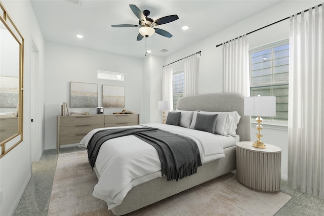 carpeted bedroom featuring baseboards, visible vents, recessed lighting, and a ceiling fan