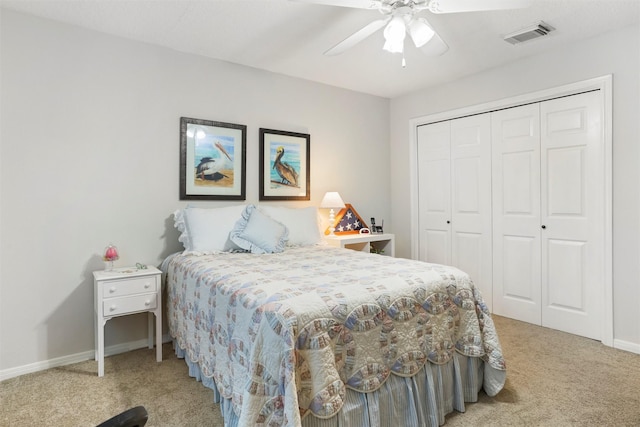 bedroom with a closet, baseboards, visible vents, and light carpet
