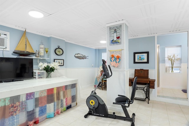 workout room featuring a wainscoted wall and tile patterned flooring