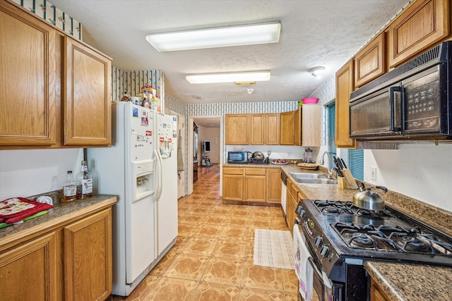 16023 Williwaw Dr, Houston, TX 77083 - kitchen featuring gas stove, a textured ceiling, a sink, black microwave, and white fridge with ice dispenser