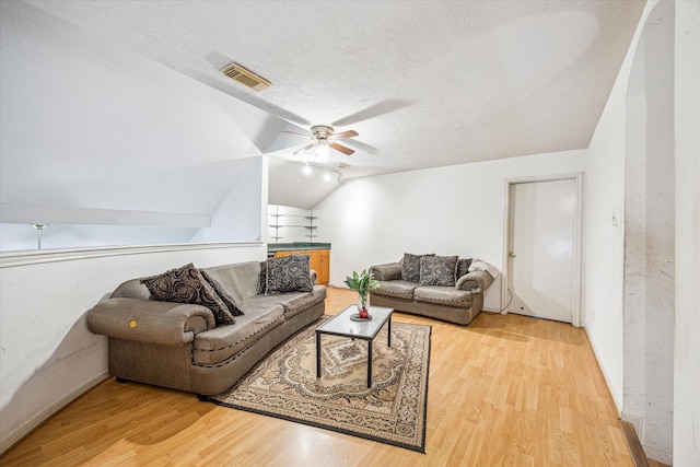 16023 Williwaw Dr, Houston, TX 77083 - living room featuring a textured ceiling, visible vents, wood finished floors, a ceiling fan, and lofted ceiling