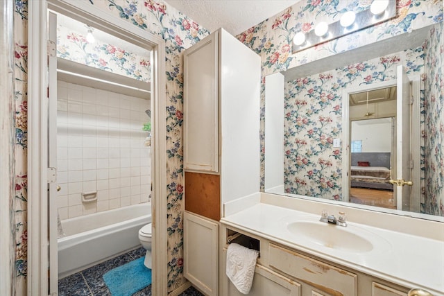 16023 Williwaw Dr, Houston, TX 77083 - bathroom with a textured ceiling, wallpapered walls, toilet, vanity, and shower / tub combo