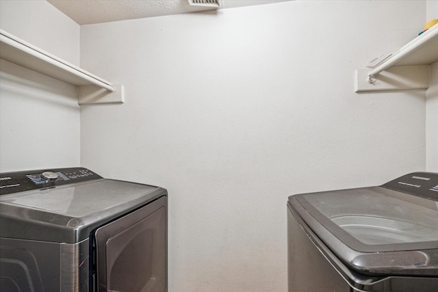 16023 Williwaw Dr, Houston, TX 77083 - laundry room featuring washing machine and dryer, visible vents, and laundry area
