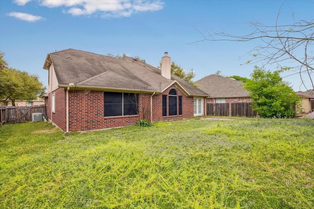 16023 Williwaw Dr, Houston, TX 77083 - rear view of house featuring central air condition unit, a chimney, brick siding, a fenced backyard, and a yard
