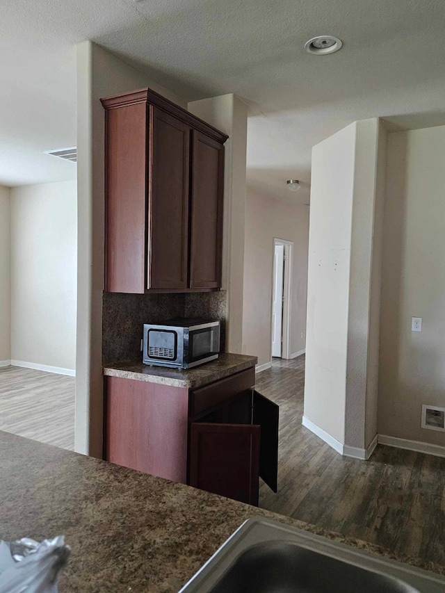 1710 Penina Dr, Crosby, TX 77532 - kitchen featuring stainless steel microwave, wood finished floors, visible vents, and baseboards