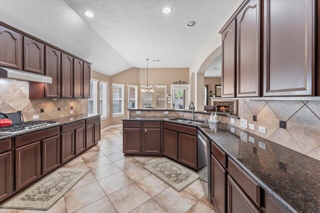 2052 Doolan Dr, Conroe, TX 77301 - kitchen featuring a sink, stainless steel appliances, lofted ceiling, backsplash, and dark stone counters