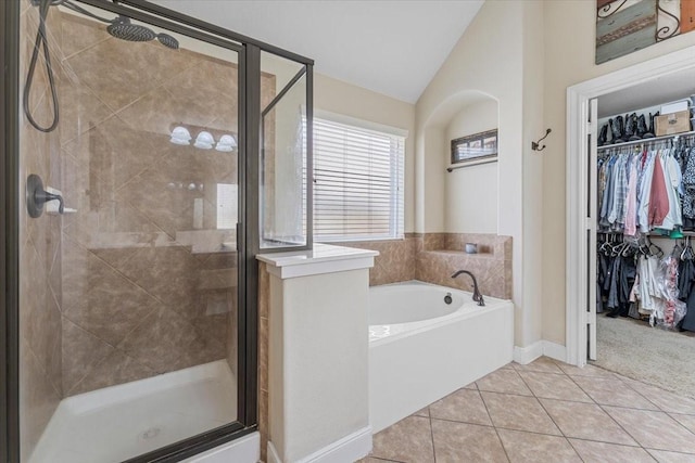 2052 Doolan Dr, Conroe, TX 77301 - full bathroom with a garden tub, a shower stall, tile patterned flooring, lofted ceiling, and a walk in closet