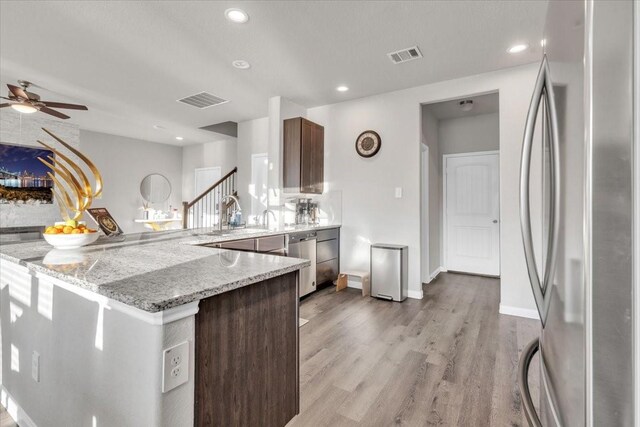5510 Brooklyn Rose Dr, Rosharon, TX 77583 - kitchen with appliances with stainless steel finishes, a peninsula, light wood-type flooring, a ceiling fan, and recessed lighting