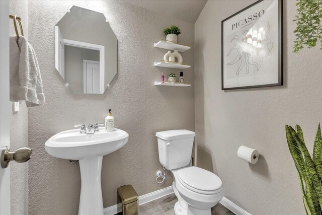 5510 Brooklyn Rose Dr, Rosharon, TX 77583 - half bathroom with toilet, wood finished floors, a sink, and baseboards