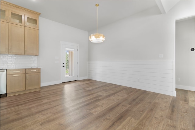 unfurnished dining area featuring wainscoting, a notable chandelier, and light wood-style flooring