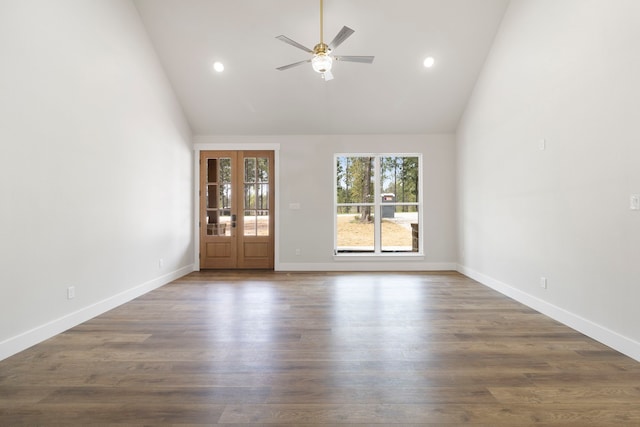 empty room featuring baseboards, high vaulted ceiling, ceiling fan, and dark wood-type flooring