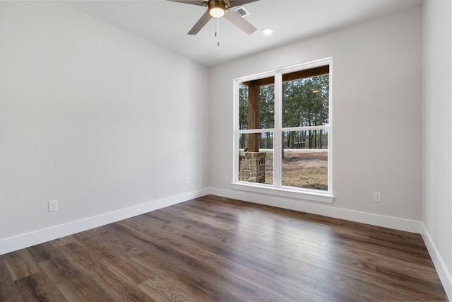 empty room featuring baseboards, dark wood-style floors, ceiling fan, and visible vents