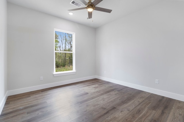 unfurnished room featuring baseboards, visible vents, wood finished floors, and ceiling fan