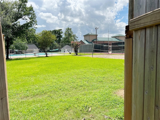 view of yard featuring fence, volleyball court, a tennis court, and a fenced in pool