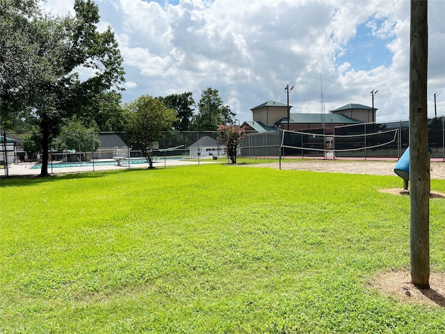 view of yard with fence, volleyball court, and a fenced in pool