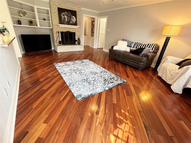 living area featuring crown molding, built in features, a fireplace, and wood-type flooring