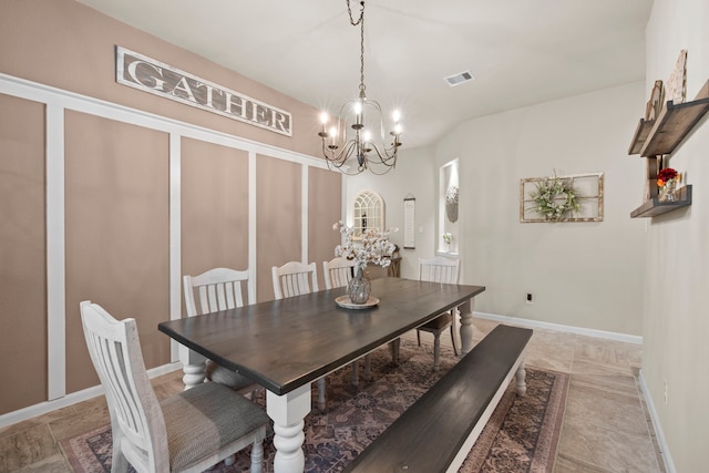 dining area with baseboards, visible vents, and a chandelier
