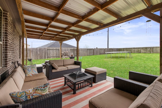 view of patio / terrace with outdoor lounge area, a trampoline, and a fenced backyard