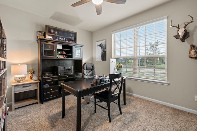 carpeted office with a ceiling fan and baseboards