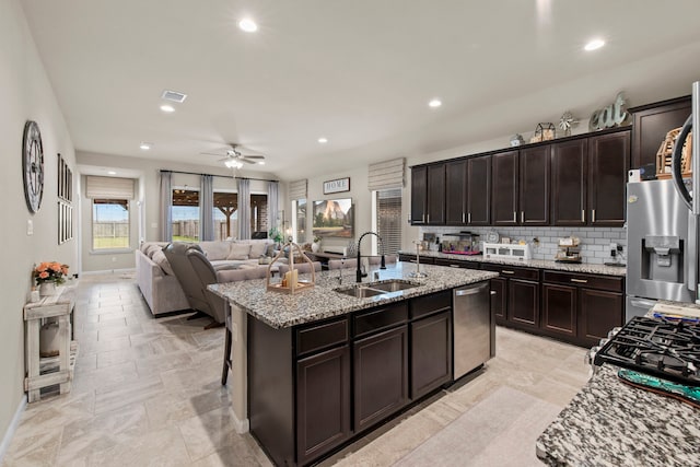 kitchen with a sink, appliances with stainless steel finishes, open floor plan, visible vents, and ceiling fan
