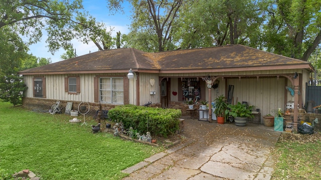 view of front of home with brick siding, a front yard, and roof with shingles