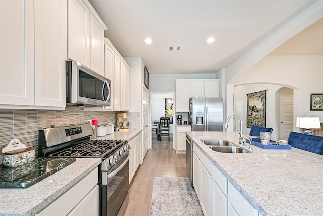13710 Alaskan Brown Bear Trl, Crosby, TX 77532 - kitchen featuring a sink, light wood-style floors, visible vents, white cabinets, and appliances with stainless steel finishes