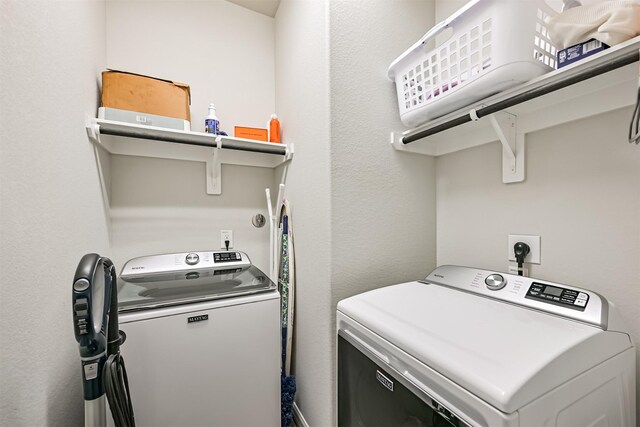 13710 Alaskan Brown Bear Trl, Crosby, TX 77532 - laundry area with washing machine and clothes dryer, laundry area, and a textured wall