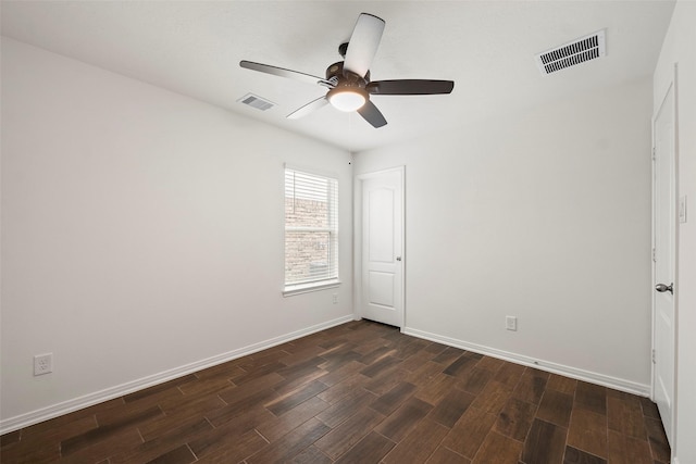 unfurnished room featuring dark wood-type flooring, baseboards, visible vents, and a ceiling fan